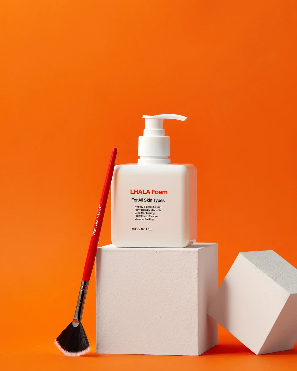 LHALA professional cleansing brush (Picasso x LHALA) beside the LHALA Foam cleanser